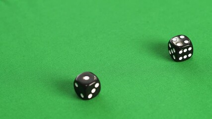 Close-up view dice playing in casino. Black dice on green table during casino game - Powered by Adobe