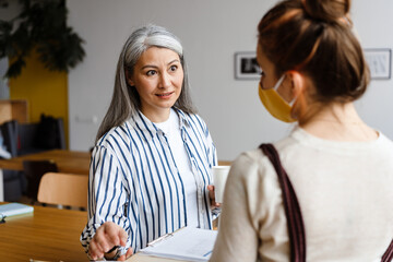 Two employee standing in social distance wearing face mask