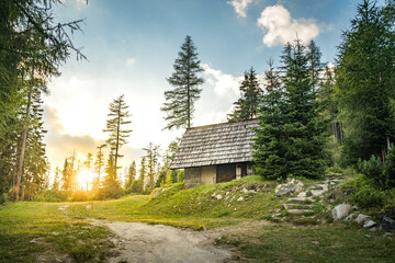 Isolated Cabin in Mountains Surrounded by Deep Forrest, sunset in background with sunrays. Slovakia...