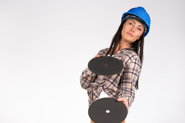 A woman in a blue hard hat poses on a white background with grinder abrasive discs. Side space.