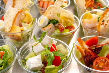catering table. Furshet. A variety of salads in plastic cups