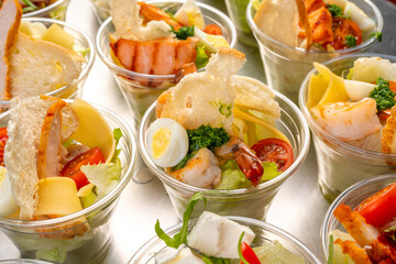 catering table. Furshet. A variety of salads in plastic cups