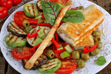 Dish of grilled vegetables with cheese wrapped in pita bread
