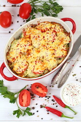 Zucchini casserole with cheese on white wooden background
