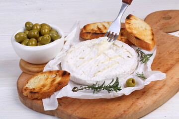 Camembert with toasted baguette on white background