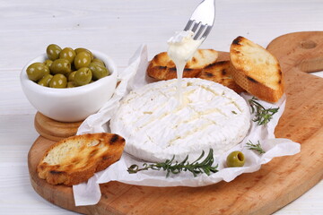 Camembert with toasted baguette on white background