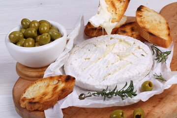 Camembert with toasted baguette on white background