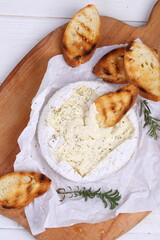 Camembert with toasted baguette on white background