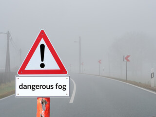 Dangerous Fog Warnschild im Straßenverkehr in einer Kurve