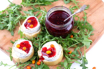 Cheese Saint-Mor-de-Touren with a glass of red wine on a white wooden background