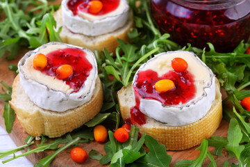 Cheese Saint-Mor-de-Touren with a glass of red wine on a white wooden background