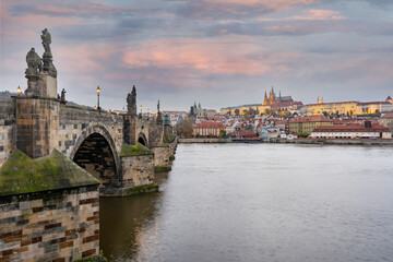 Fototapeta na wymiar Prague Castle and St. Vitus Cathedral and the flowing Vltava River and statues and a street lamp on Charles Bridge in the center of Prague