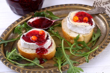 Cheese Saint-Mor-de-Touren with a glass of red wine on a white wooden background