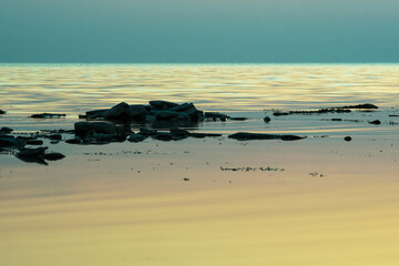 calm sea after sunset on the rocky coast