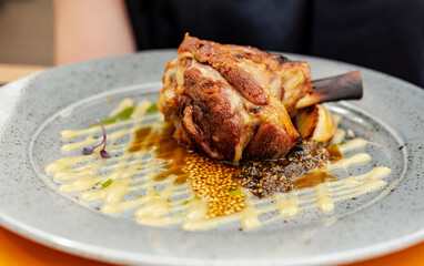 A nice lamb shank on a plate.