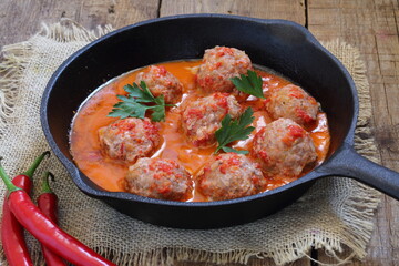 Meatballs in a ceramic plate with beer on a wooden table