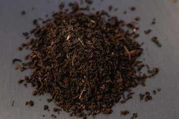 a slide of black tea on a dark stone background