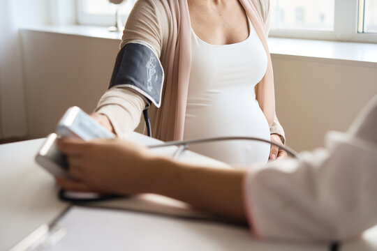 Doctor measuring blood pressure of her pregnant patient. High quality photo