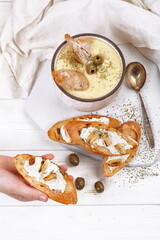 French puree soup with parsnip, soft cheese baguette. Holds a soft cheese sandwich