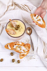 French puree soup with parsnip, soft cheese baguette. Holds a soft cheese sandwich