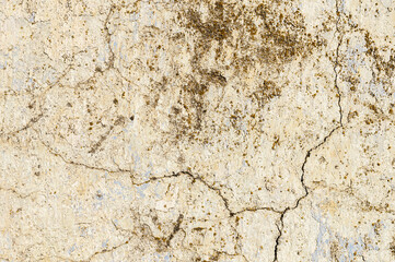Grunge background of cracked peeling walls with peeled putty in beige tones