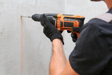 person hands hold hammer drill close up 