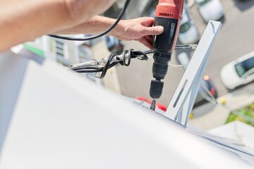 Installing the outdoor unit of the air conditioner, using drill fixing the unit holders