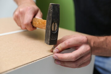 furniture assembler assembles a kitchen cabinet. men hands install new furniture close-up. furniture assembling service concept