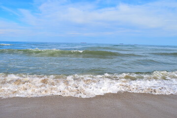 Sea view with cargo ships floating in the distance.