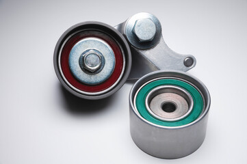 Two tensioning rollers of the engine timing belt on a gray background. New spare parts for car engine repair