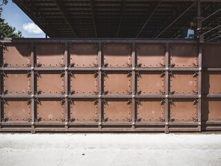 Iron brown fence with a forged pattern in the form of squares with decorative elements