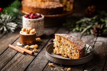 Traditional Christmas cake pudding with fruits and nuts with Christmas decorations, dark background