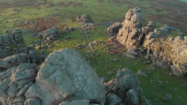 Aerial drone footage of natural granite rock formations of Hound Tor and green countryside, Dartmoor National Park