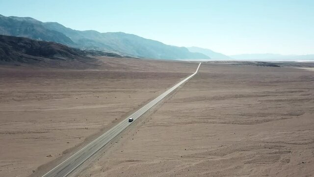 Tracking Aerial Shot Of A Car Driving On Badwater Road In Death Valley National Park