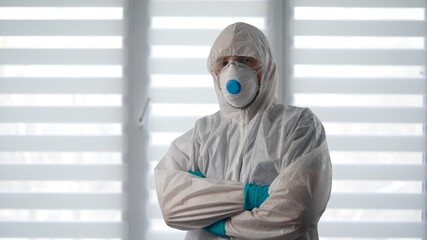 Fototapeta na wymiar Pandemic Covid-19. Portrait of a virologist in a protective suit. A male epidemiologist is ready to fight the infection.