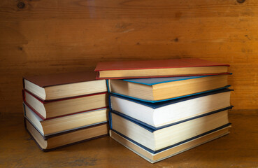 Stack of the books rests upon wooden regiment