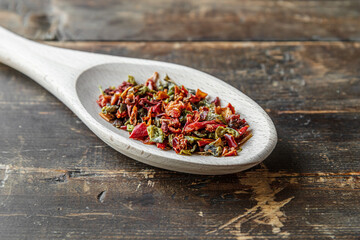 paprika flakes spice on a wooden spoon