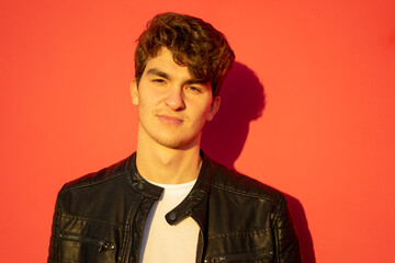 Obraz premium horizontal shot of portrait of attractive young man looking at camera on red color background