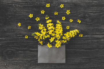 Craft envelope with yellow flowers on wooden table.