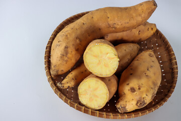 Ubi jalar kuning or yellow sweet potato on the pandanus mat. Selective focus