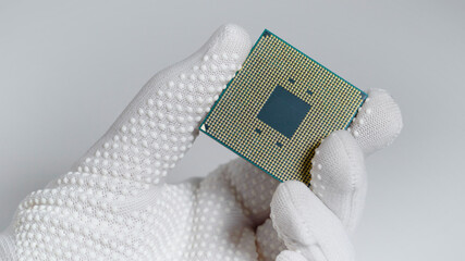 CPU. A laboratory technician holds a powerful processor in his hands. A group of scientists is working in the field of artificial intelligence.
