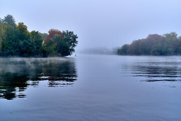 Herbstlandschaft bei Regen und Nebel über dem Wasser