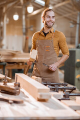 Portrait of a handsome carpenter at the joiner's shop