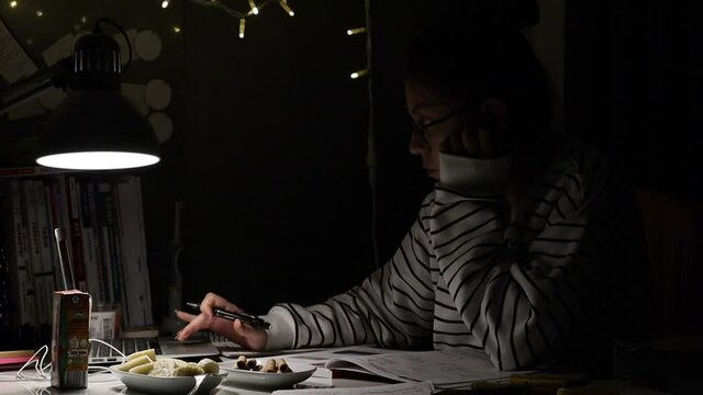 A student scrolling laptop studying at night