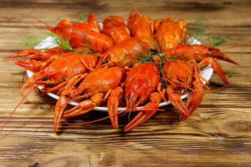 Boiled crayfish in plate on wooden table