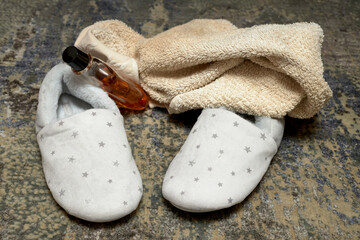 Zapatillas caseras de mujer con una toalla y colonia