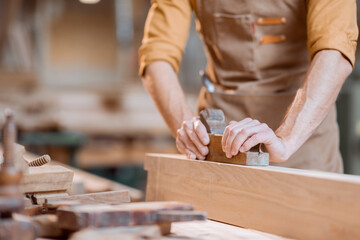 Carpenter working with a wood in the workshop
