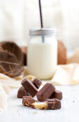 Toffee sweets in chocolate, caramel candies, confectionery and healthy food concept - close-up on the table