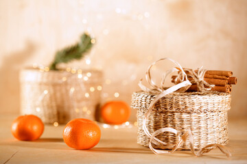 Chrismas mood still life: cinnamon, anise, tangerines, pine cones and gift box in golden christmas lights