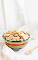 Crispy corn pads in a clay bowl with a bottle of fresh milk on a light background. Healthy breakfast cereals. Amaranth pads Copy space